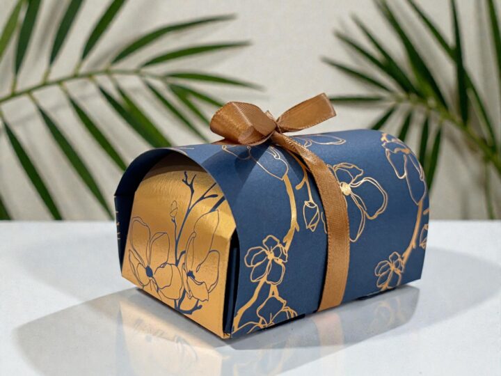 Navy Belgian chocolate favor box with gold floral pattern and brown ribbon bow