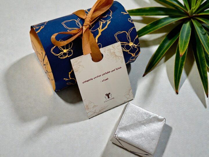 Navy Belgian chocolate favor box with personalized tag and wrapped chocolate piece