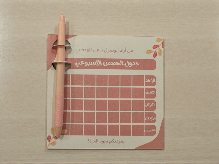 كرت جدول الحصص الأسبوعي وردي غامق مع قلم حبر أزرق